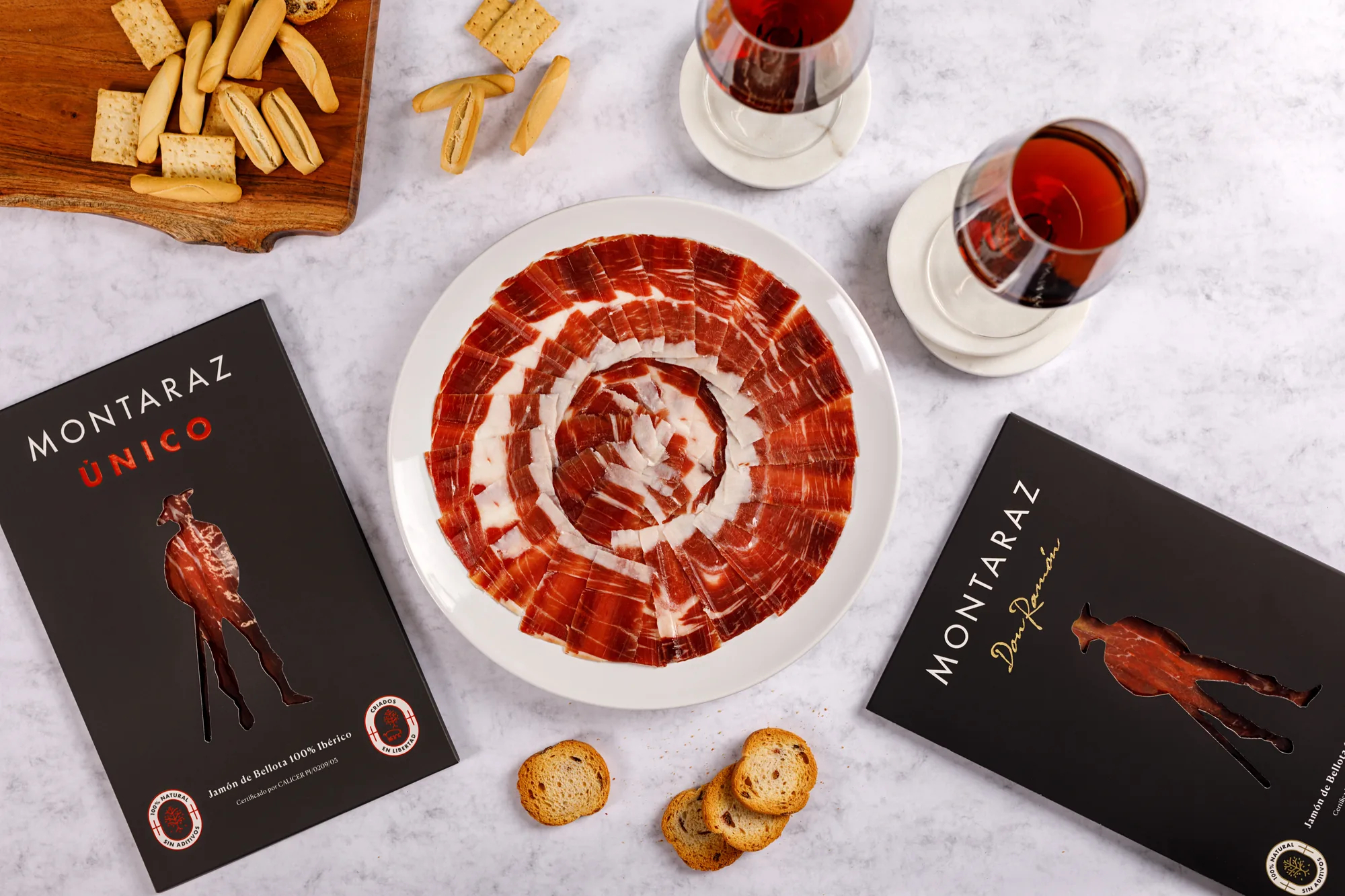 Plato de jamón de bellota 100% ibérico loncheado con estuches Montaraz Único y Don Ramón